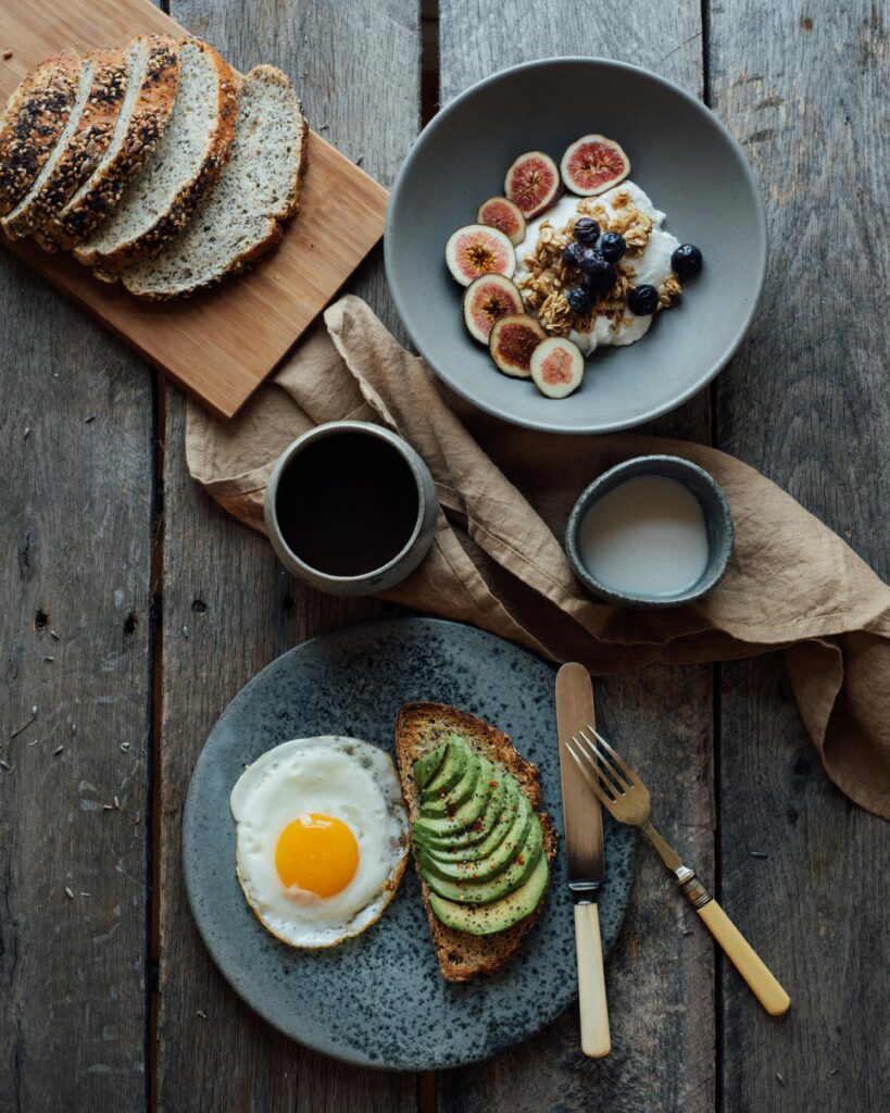 pexels photo 5591663 5591663 Healthy breakfast with avocado toast, eggs, and yogurt with figs and berries on a wooden table.